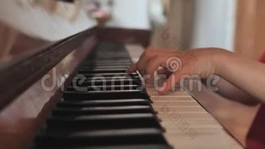 一个七岁的男孩在家弹钢琴。 一个男孩的手特写。